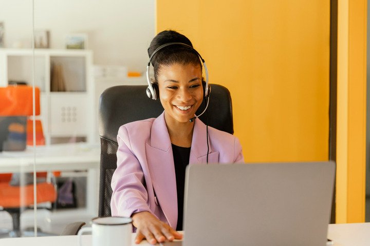 woman wearing her head phones sitting behind a laptop