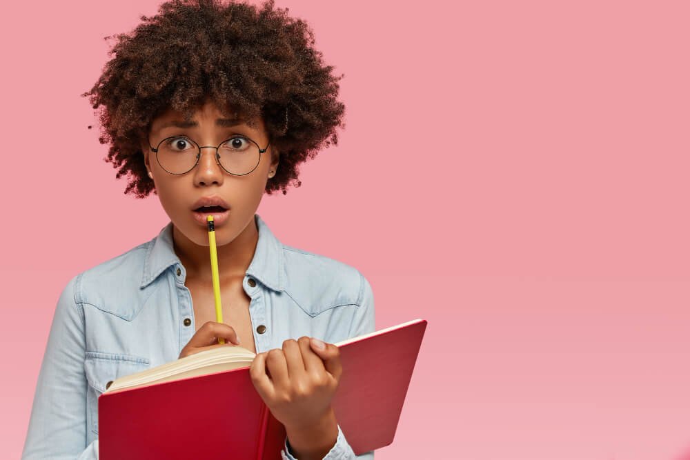 a woman holding a book and a pen